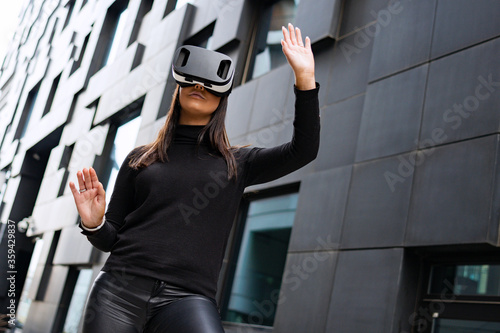 Woman Portrait Using Virtual Reality Glasses And Black Outfit In Futuristic City
