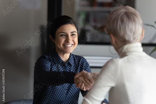 Happy employer HR manager shaking hands with indian job seeker welcoming vacancy applicant. Successful manager making deal with partner, good positive first impression, start business meeting concept