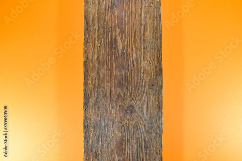 Stara brązowa deska na pomarańczowym tle. 