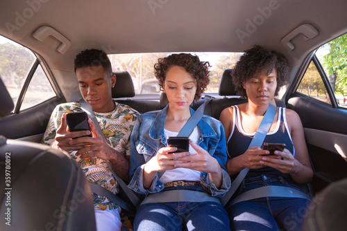 Young people using cellphone inside car.
