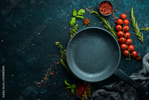 Culinary banner. Frying pan with vegetables on a black stone background. Top view. Rustic style.