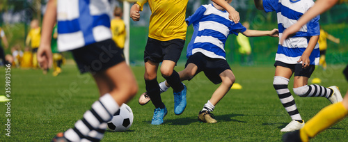 Soccer Players Run. Young Boys Running After Ball During Football Tournament Match. Sports School Competition for Children. Junior Level Soccer Game. Players in Red and Yellow Jersey Sport Clothing