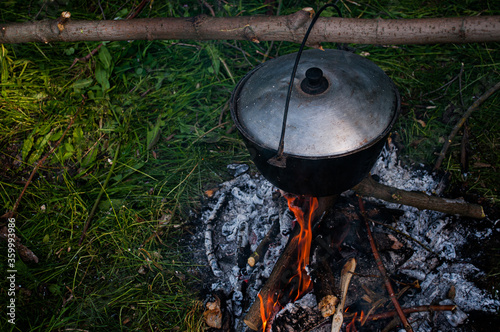 Big cauldron on the grass. Food preparation in forest.