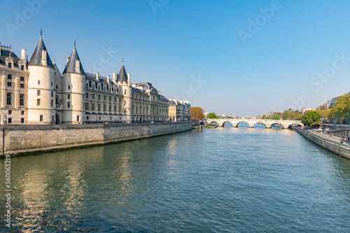 View of medieval palace Conciergerie, Seine river with barge and Neuf bridge in Paris, France