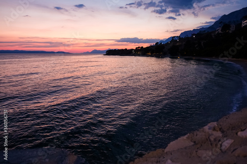 Podgora Chorwacja, zachód słońca nad brzegiem morza, piękne intensywne kolory, wieczorowa pora.
