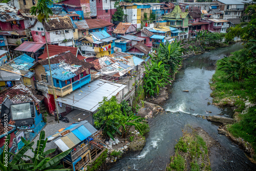 Colorful homes tightly packed together along a river in Indonesia.