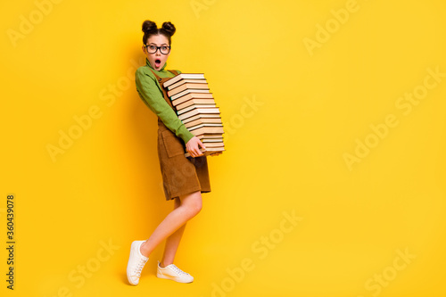 Full length body size profile side view of her she attractive overwhelmed stunned knowledgeable girl carrying many different paper book isolated bright vivid shine vibrant yellow color background