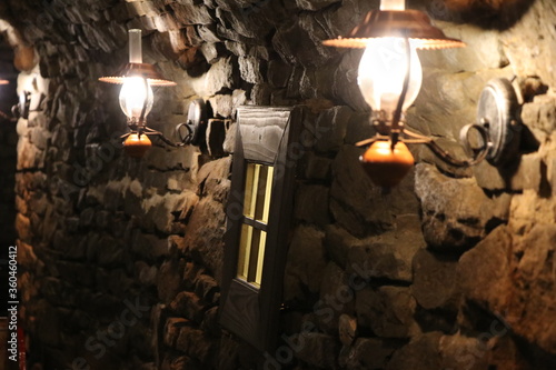 Lampy naftowe oświetlające stary mur