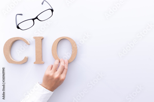 CIO（最高情報責任者）のロゴと男性の手とメガネ