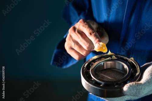 Mechanic is putting yellow grease in the into bearing, engineering and industrial concept.