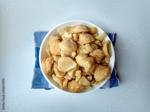 Aleurites moluccanus or Indonesian Candlenuts called Kemiri, inside a bowl, isolated in white background