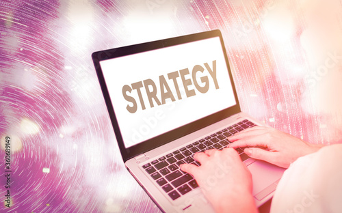 Handwriting text writing Strategy. Conceptual photo action plan or strategy designed to achieve an overall goal Modern gadgets with white display screen under colorful bokeh background