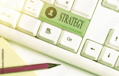 Word writing text Strategy. Business photo showcasing action plan or strategy designed to achieve an overall goal White pc keyboard with empty note paper above white key copy space