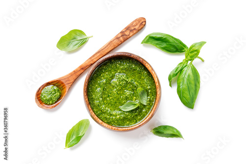 Traditional italian sauce pesto with green basil in wooden bowl isolated on white background