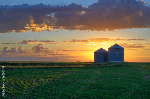 Prairie sunrise on metal grain bins near the city of Moose Jaw, Saskatchewan, Canada