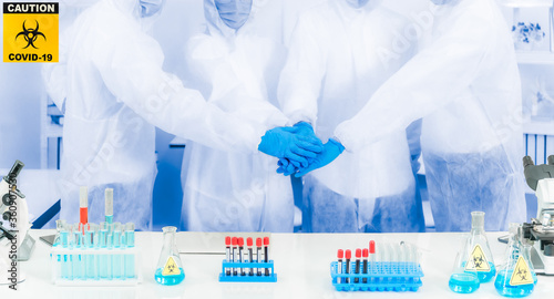 Group of medical researcher standing and putting stacking their hands for agree to start project