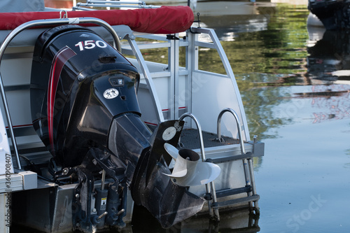Outboard motor attached to pontoon boat on the water