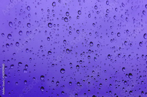 banner of a drop of water on glass in a purple glow. space for text..