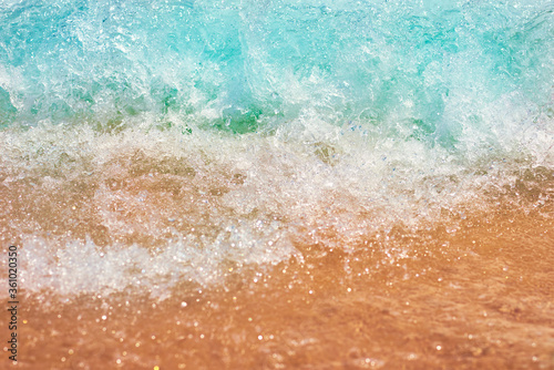 Sea wave on the sand beach, soft focus. Summer background