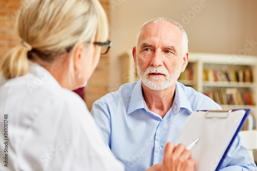 Senior Patient hört seiner Ärztin aufmerksam zu