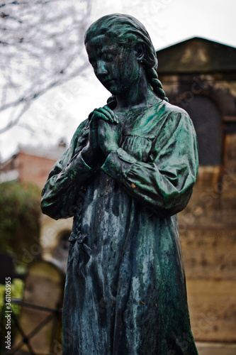 Statue of a girl in a graveyard in Paris