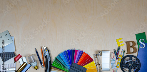 Advertising materials and samples on silver background. Colour palette, plastic and metal samples, tools, lighting components.