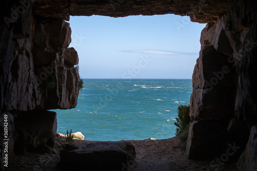 Sunny ocean view looking out through a rocky cave.