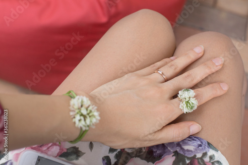 Female hand in a four-leaf clover flowers ring.