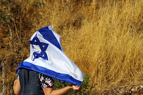 Holocaust memorial day concept: Jewish teenager with Israeli flag laying on his head and shoulders in memory of the dead Jews during World War II