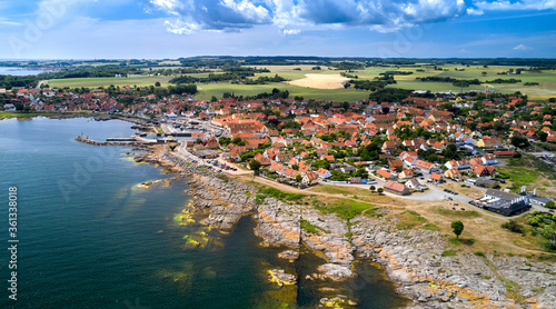 Panorama der dänischen Stadt Svaneke auf der Insel Bornholm an einem Sommertag mit Blick auf die Granitfelsen und Häuser mit roten Dächern.