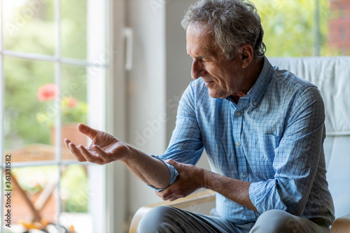 Senior man with arthritis rubbing hands 