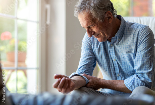 Senior man with arthritis rubbing hands 