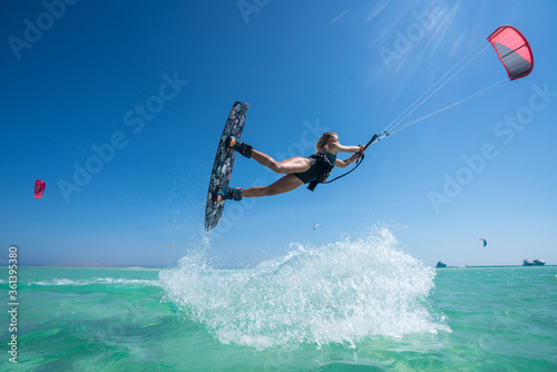 Kite girl rides in the ocean clear water