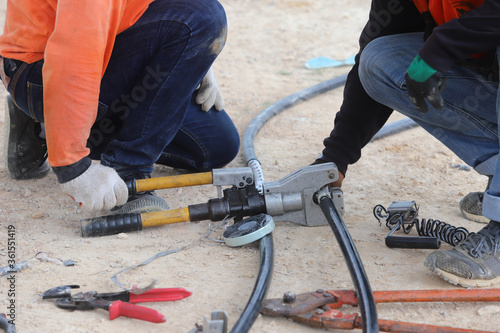 The electrician is connecting the high voltage cables together.