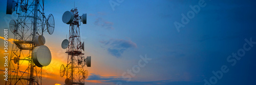 Telecommunication towers with wireless antennas on sunset sky