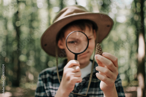 Boy biologist or entomologist studies nature. Scout in the forest. A teenager studies insects. Biology. Geology. Expedition in the forest.