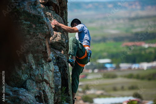 Man climbing a very steep mountain -Rock Climbing