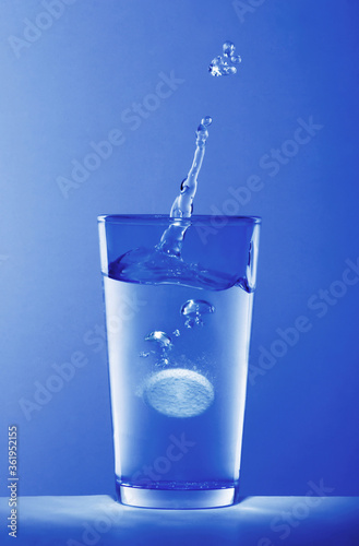 Soluble pill dropping into a glass of water