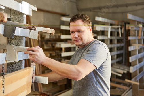 Carpenter apprentice gluing wood in carpentry