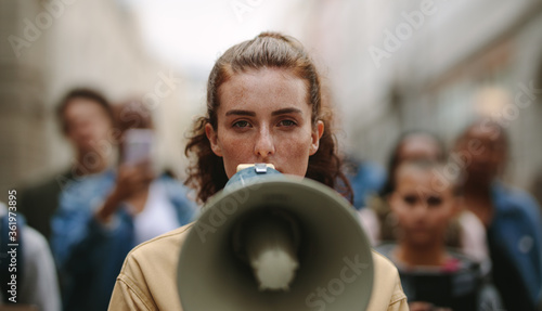 Female activist protesting with megaphone during a strike