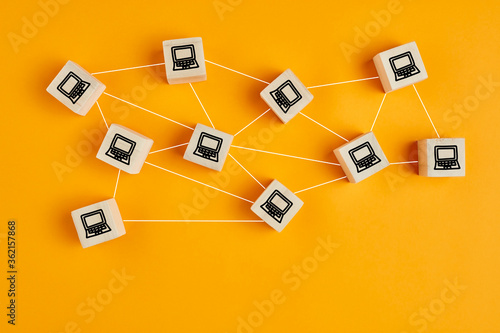 Concept of computer network or communication. Wooden cubes with computer icons connected to each other on a network