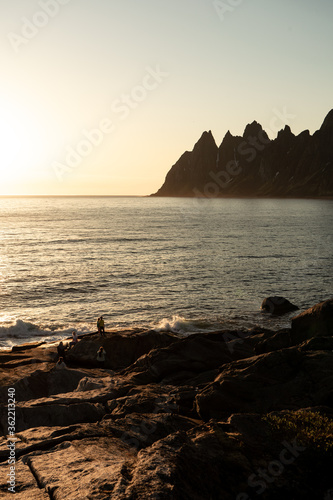Summer time on Senja island, Norway. Relaxed people, beautiful sunset during the white night, amazing sharp mountains and norwegian sea in the background.