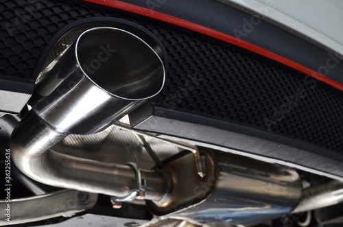 New generation of sportive mufflers. Oval or round Car Exhaust Tailpipe chromed made of stainless steel on powerful sport car bumper. Close up