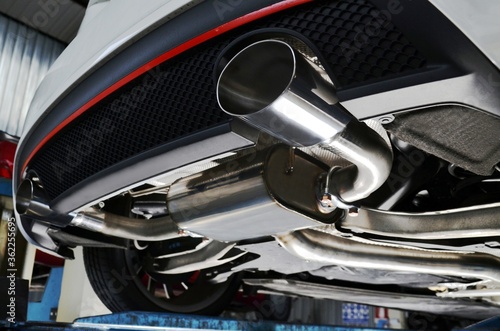 New generation of sportive mufflers. Oval or round Car Exhaust Tailpipe chromed made of stainless steel on powerful sport car bumper. Close up