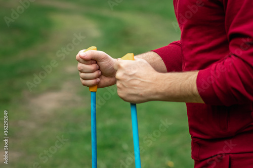 Nordic walking, sticks, hands close-up. The concept of a healthy lifestyle, cardio training. Copyspace.