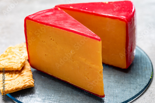 Red waxed yellow cheddar cheese and crackers with grated cheese