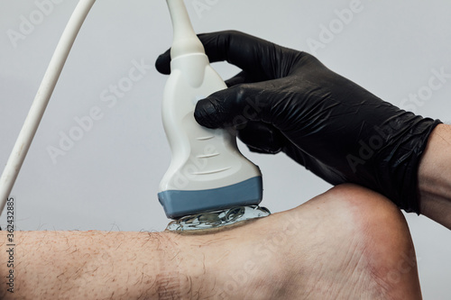 Detail of hand doing an ultrasound scan of the achilles tendon