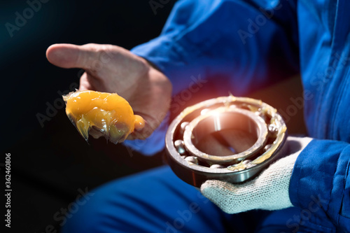 Mechanic is putting yellow grease in the into bearing, engineering and industrial concept.