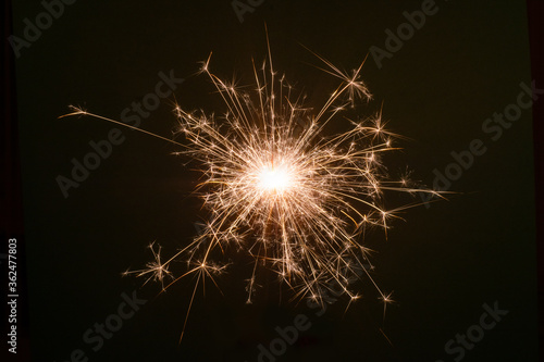 New Year Christmas sparkler on dark background with bokeh lights