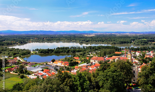 Picturesque aerial view at the famous Czech town Hluboka nad Vltavou from the castle on the blue sky background.